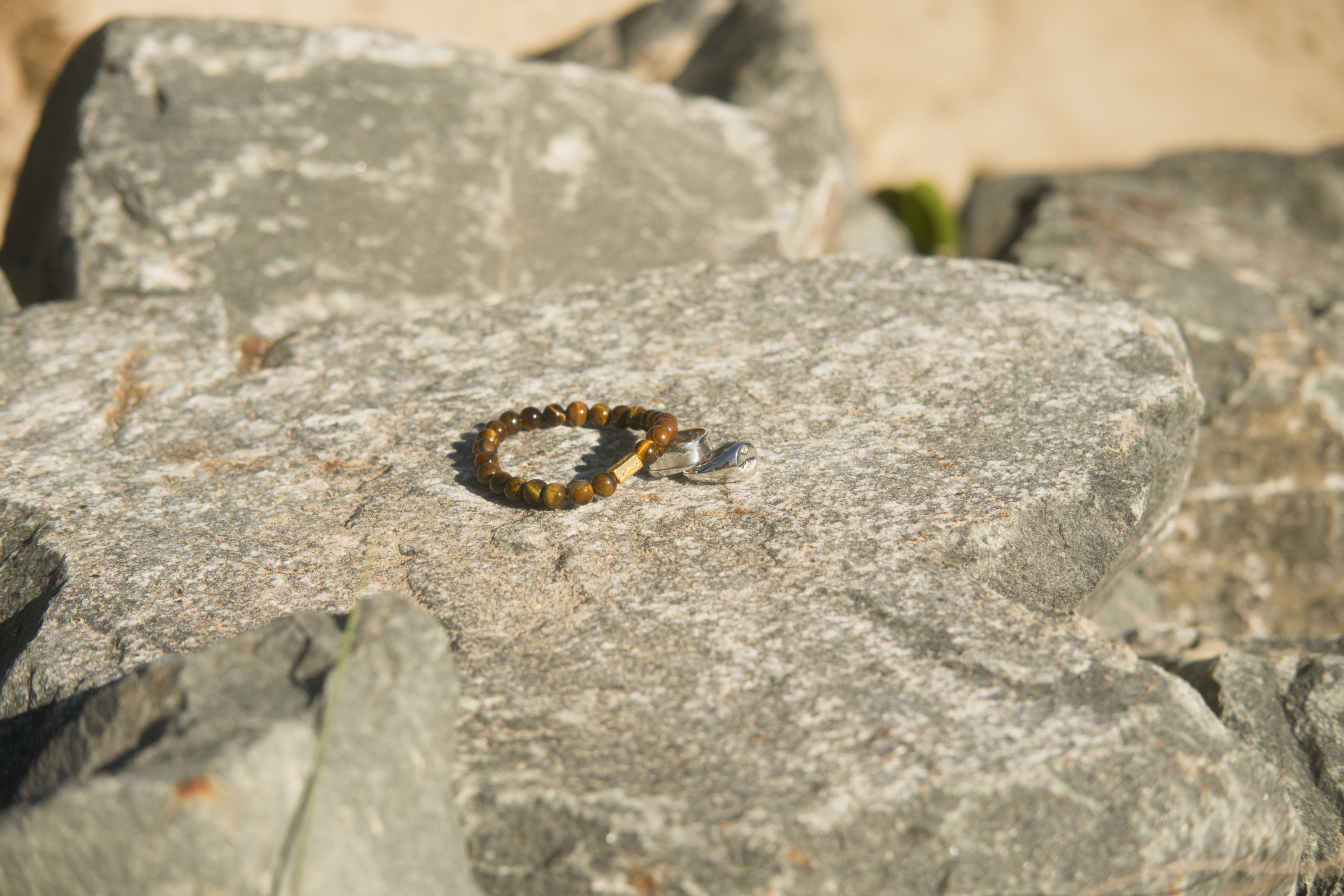 3 pieces of jewellery sitting atop a gray stone.